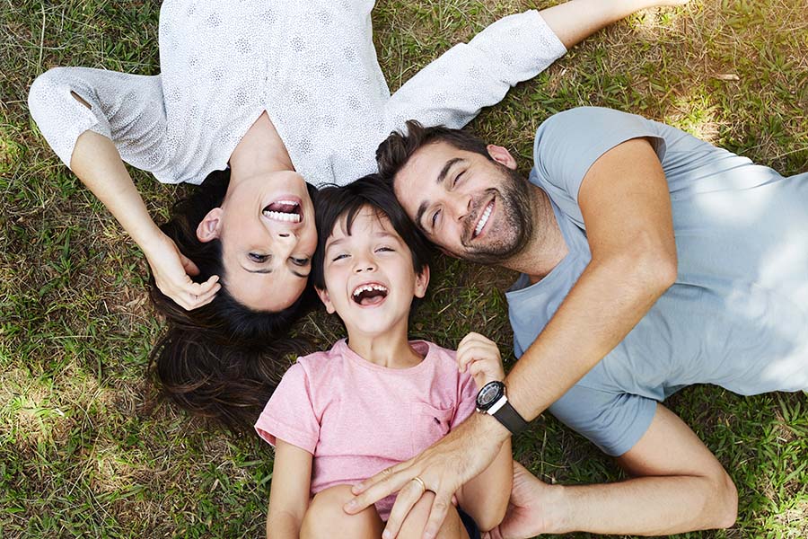 Personal Insurance - Portrait of a Smiling Family with a Young Boy Having Fun Playing in the Park
